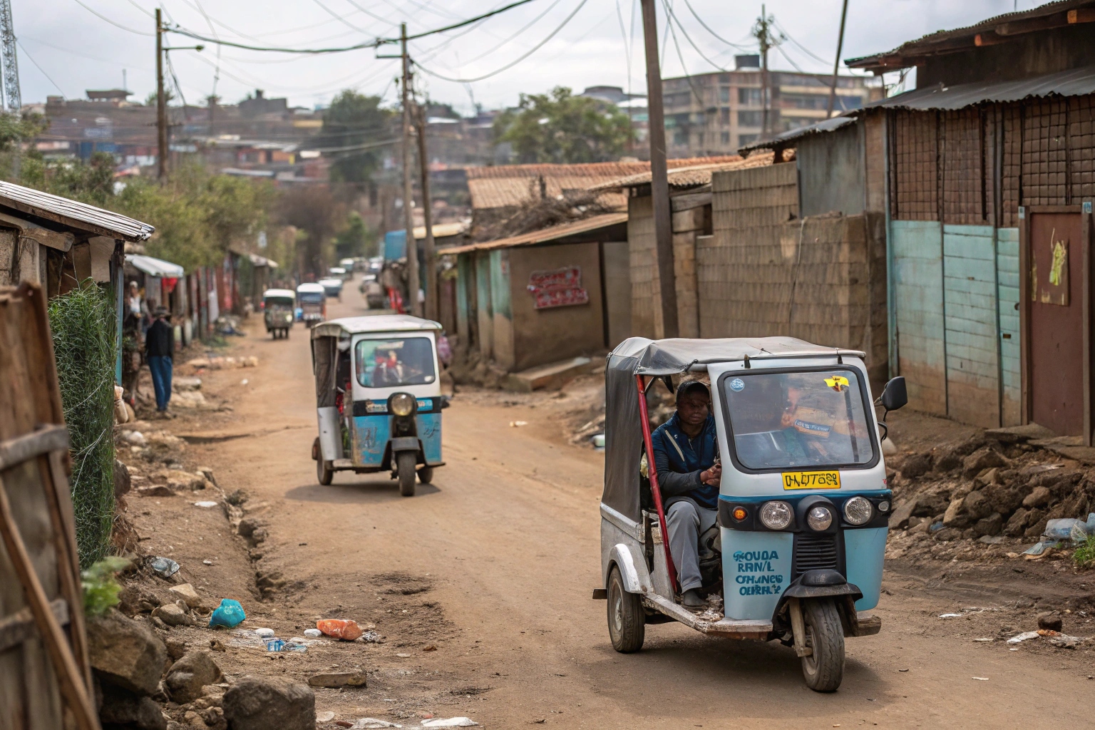 a small electric waste tricycle navigating a narrow, busy street in an African city