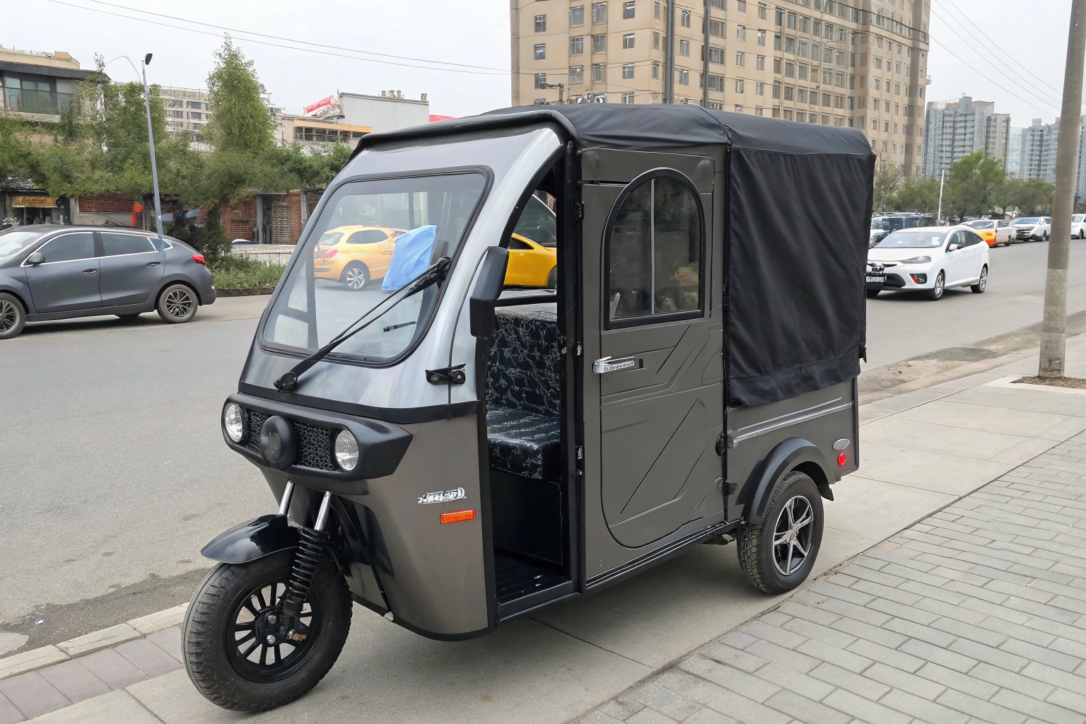 a sleek electric enclosed tricycle parked on a city street
