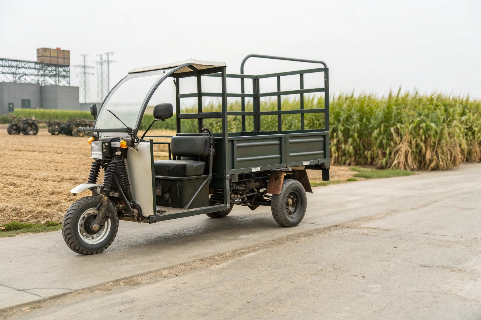 A farmer easily swapping a battery on an electric tricycle in a barn