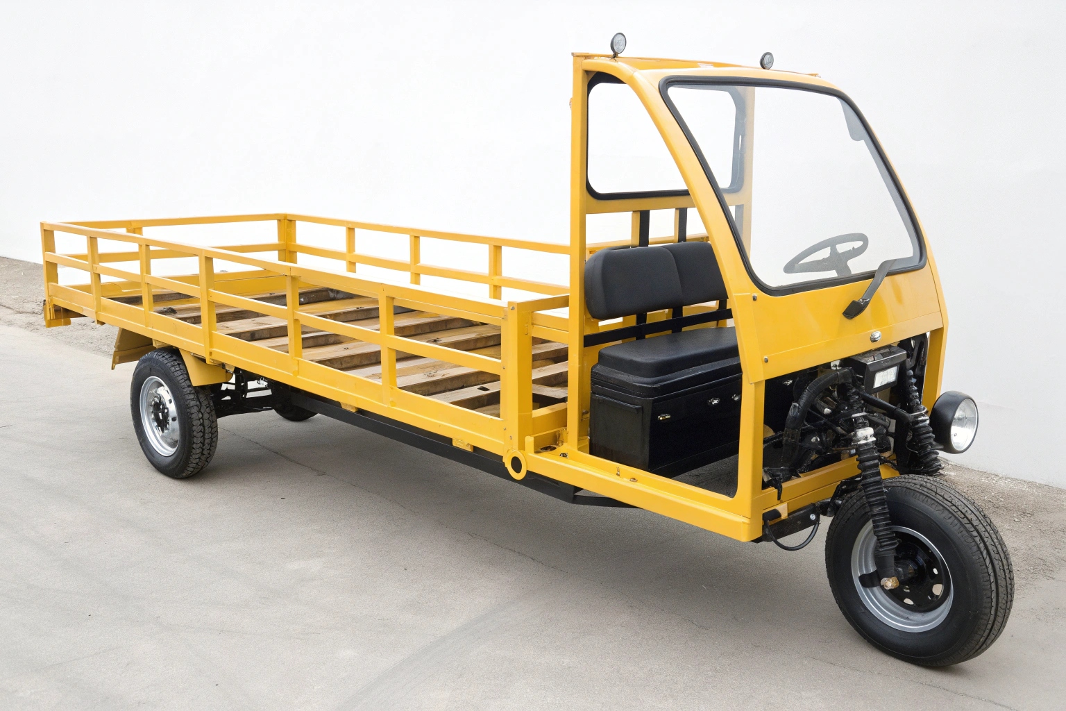 A view from below an electric tricycle, showing its reinforced frame and high ground clearance
