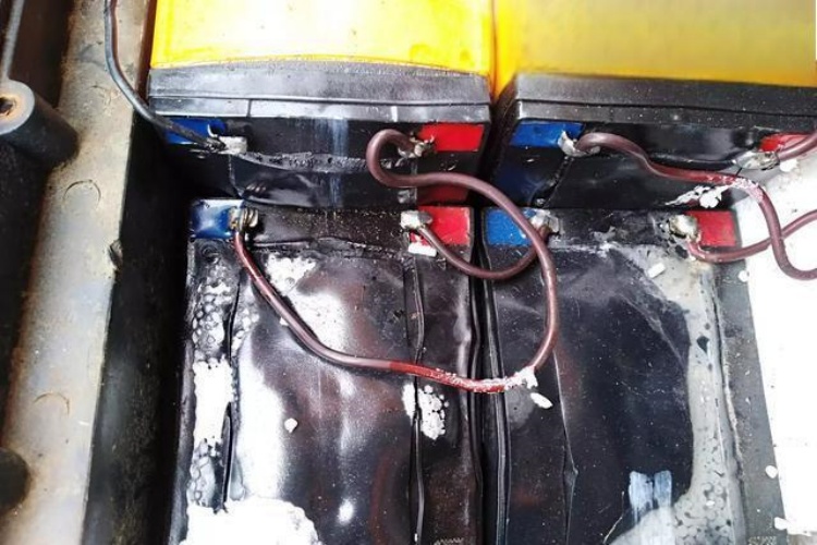 A close-up of an electric tricycle battery pack with terminals visible