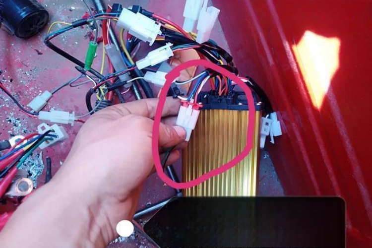 A person pushing an electric tricycle to check if it rolls freely