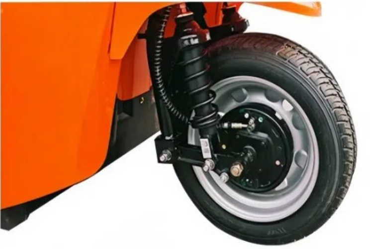 A close-up of a swing arm front suspension on an electric rickshaw